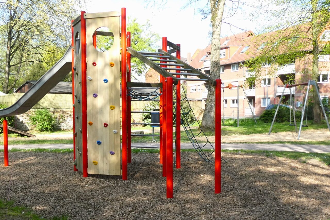 Der Spielplatz nach der Umgestaltung. Zu sehen ist ein Klettergerüst, eine Seilbahn und eine Rutsche-