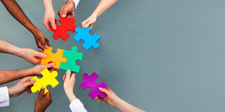 High Angle View Of Medical Team Solving Jigsaw Puzzle