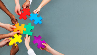 High Angle View Of Medical Team Solving Jigsaw Puzzle