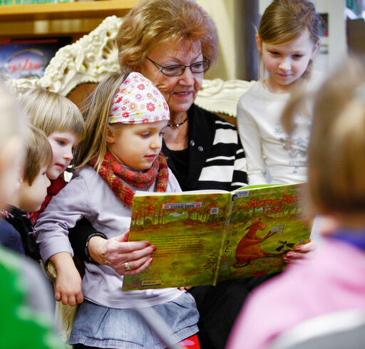 Frau liest Kindern vor.