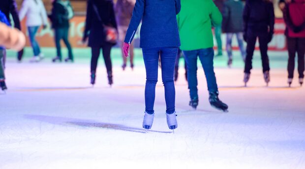 Leute mit Schlittschuhen auf der Eisbahn