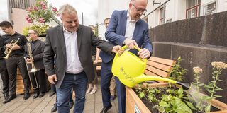 Oberbürgermeister Sören Link und Umweltdezernent Matthias Börger begießen die erste "Grüne Bank"