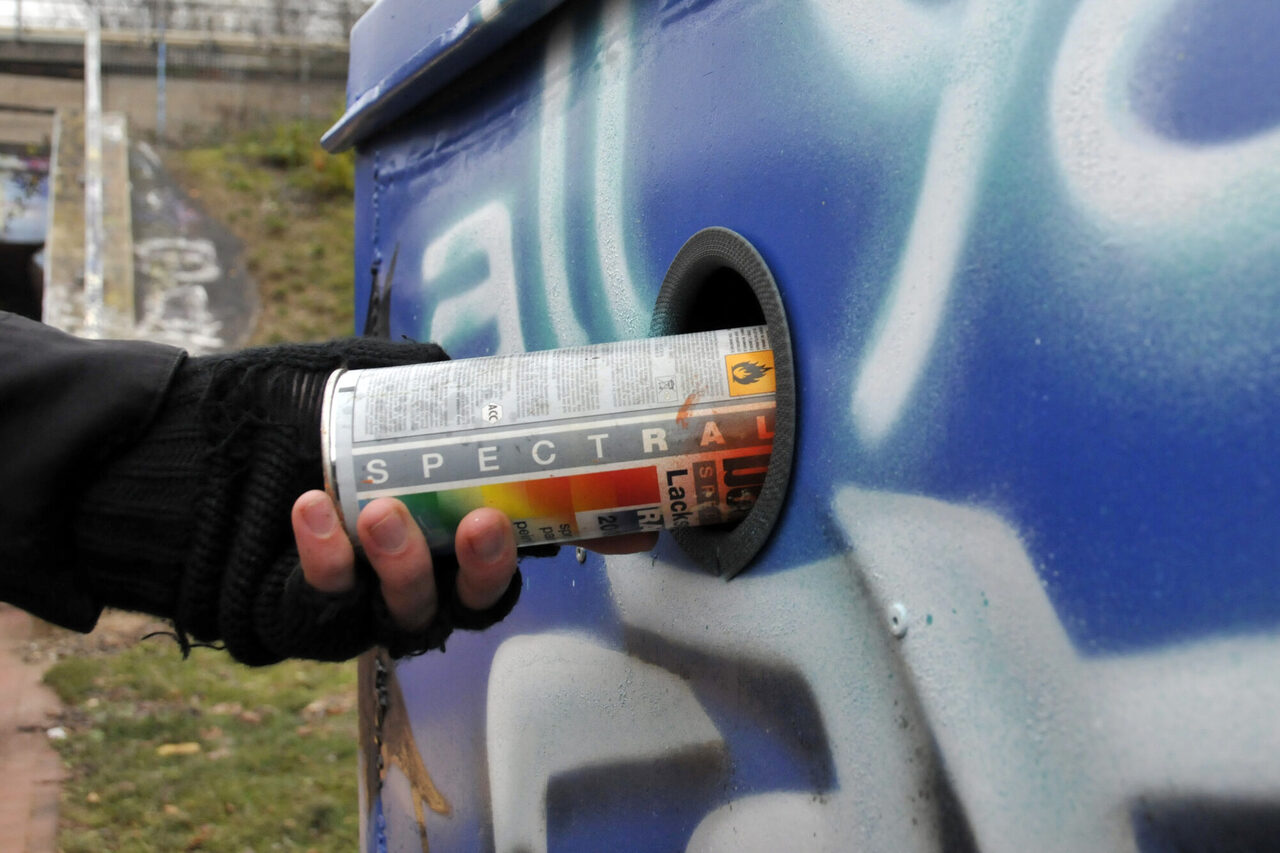 Einwerfen einer Sprühdose in den Abfalleimer