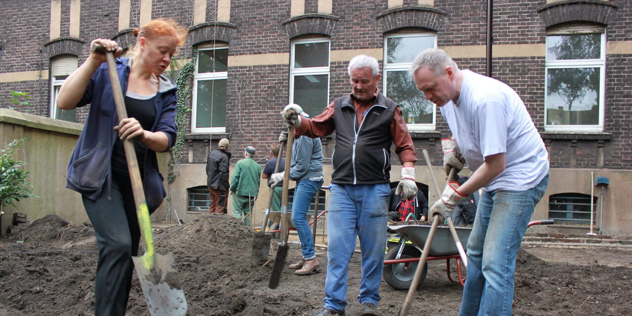 Menschen graben ein Beet um
