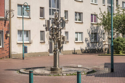 Brüll-Brunnen (1969/1971) an der Straßenecke Feld-/Wilhelmstraße in Marxloh. Will Brüll (1922-12019), Bildhauer aus Viersen, arbeitete haupsächlich mit rostfreiem Stahl. Im Stadtgebiet sind mehrere Arbeiten von ihm aufgestellt.