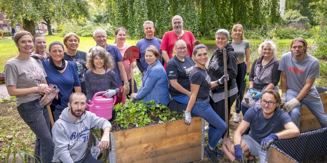 Gruppenbild der Mitarbeitenden von der Commerz Direktservice GmbH mit Harke und Schaufel