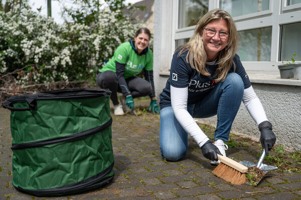 Mit Fugenkratzer und Besen gegen das Unkraut auf der Terrasse