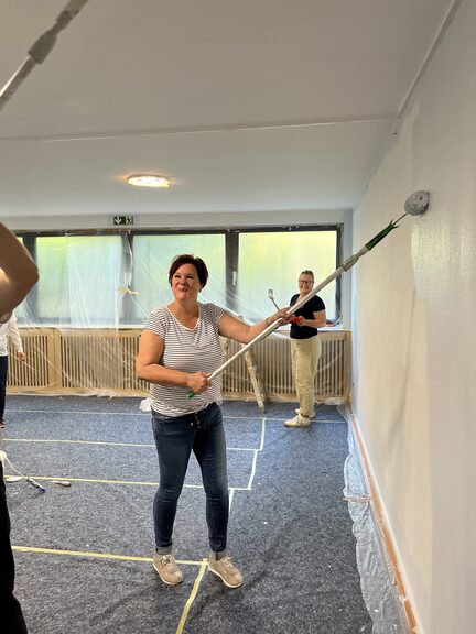 Eine Mitarbeiterin von Aurelis streicht die Wand.