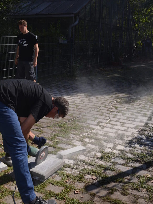 Mitarbeiter schneiden Steine für die Fläche des Gerätehauses