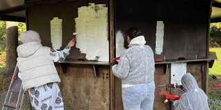 Mitarbeiterinnen und Mitarbeiter der Targobank grundieren eine Hütte