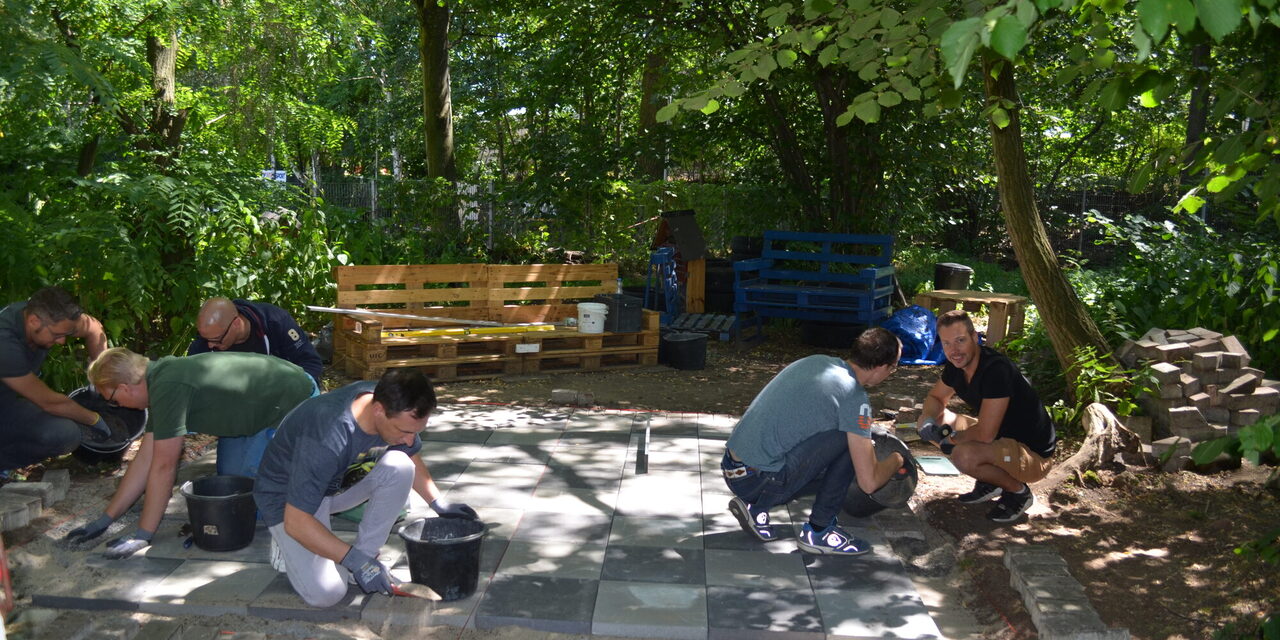 Mitarbeiter verlegen Steine für ein Schachbrett