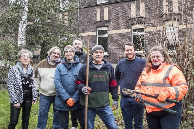 Ein TEAM der TARGOBANK im Außengelände mit Schere und Rechen