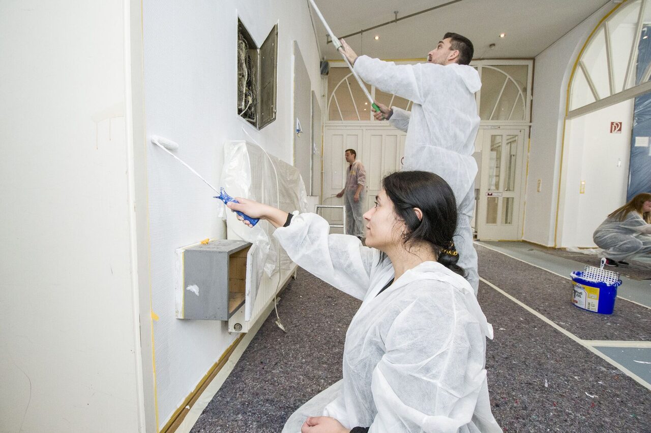 Vier Personen streichen Wände