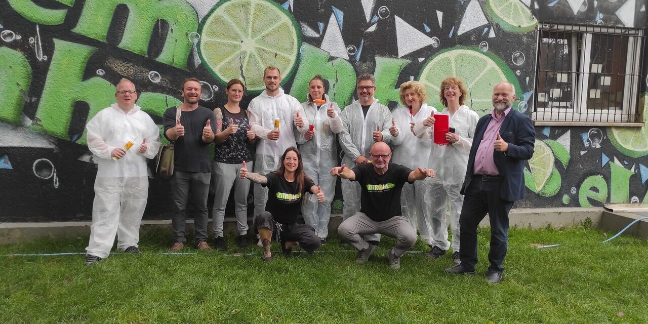 Mitarbeitende von TotalEnergies im Arbeitsdress vor dem Jugendzentrum