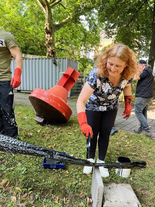Mitarbeiterin beim Streichen des Ankers
