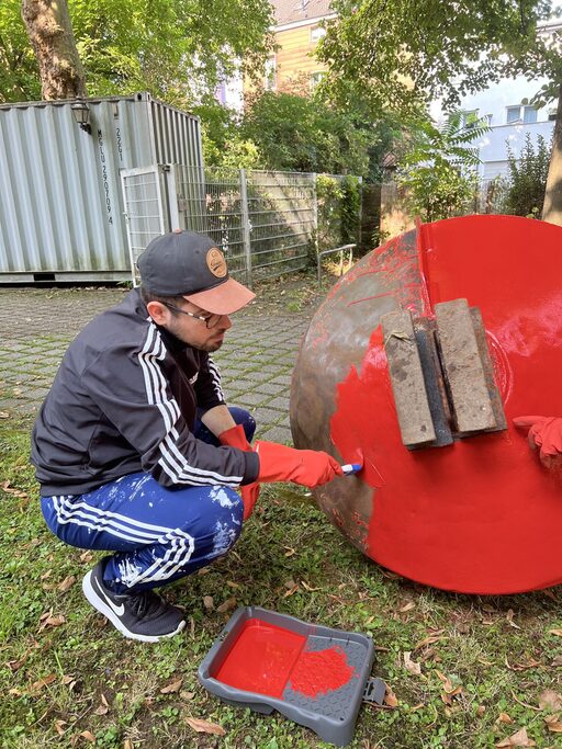 Mitarbeiter beim Streichen der roten Boje
