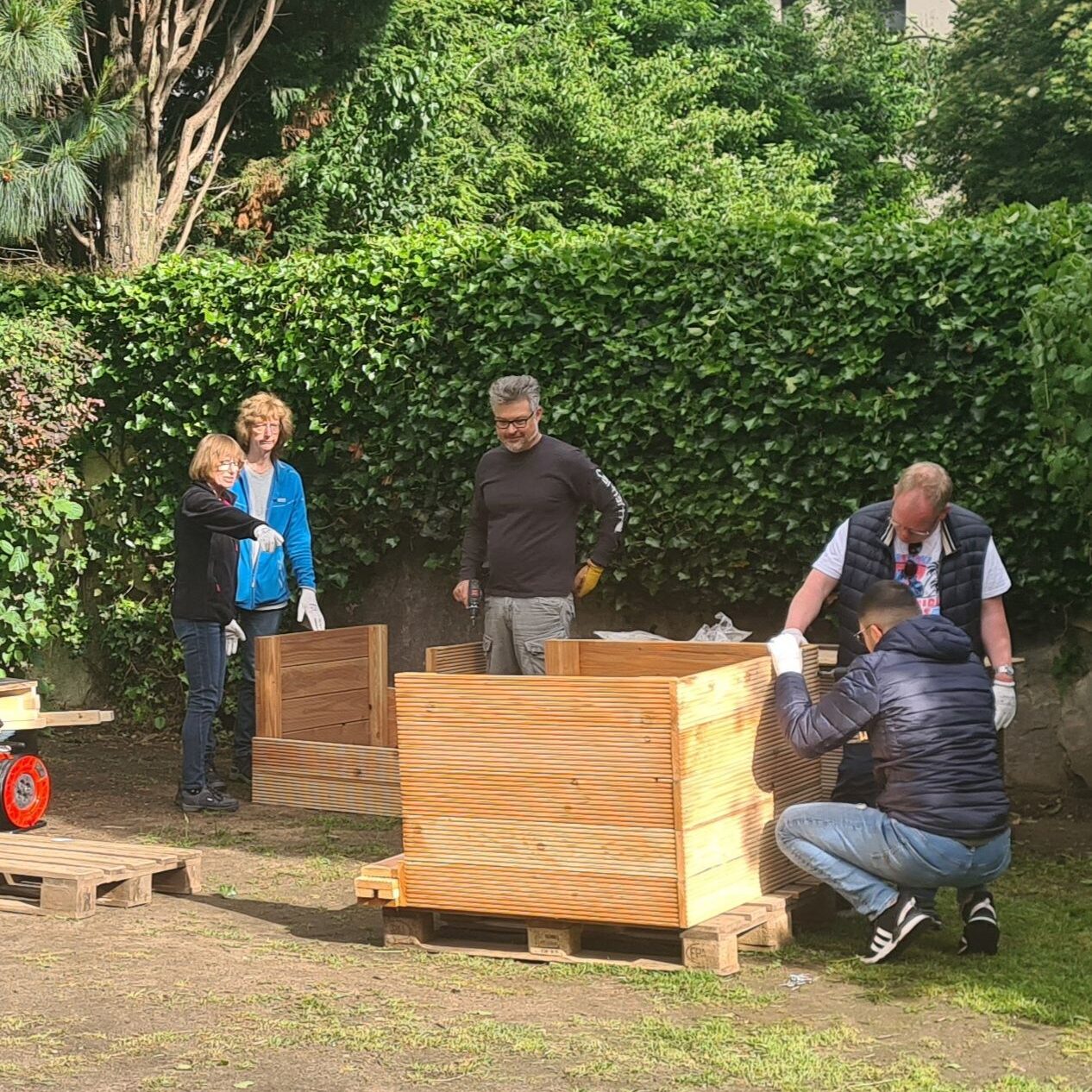 Mitarbeitende beim Aufbau der Hochbeete