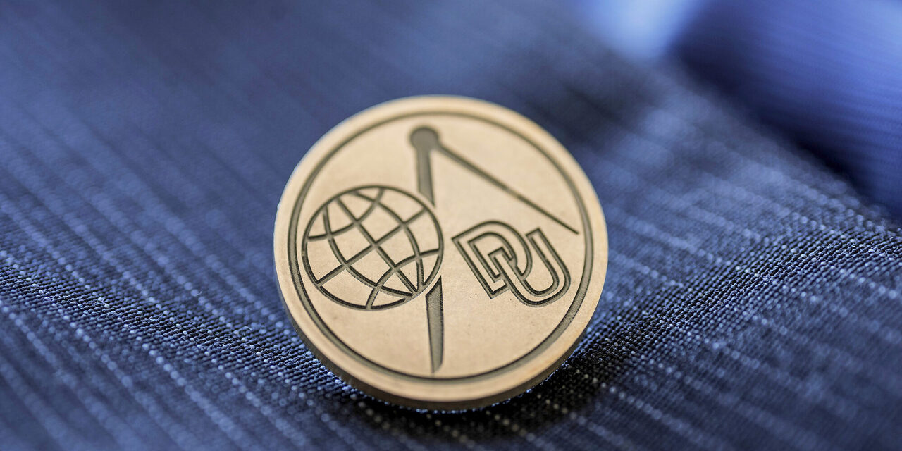 Bild der Mercator Ehrennadel mit stilisiertem Globus, Zirkel und DU als Abkürzung für Duisburg