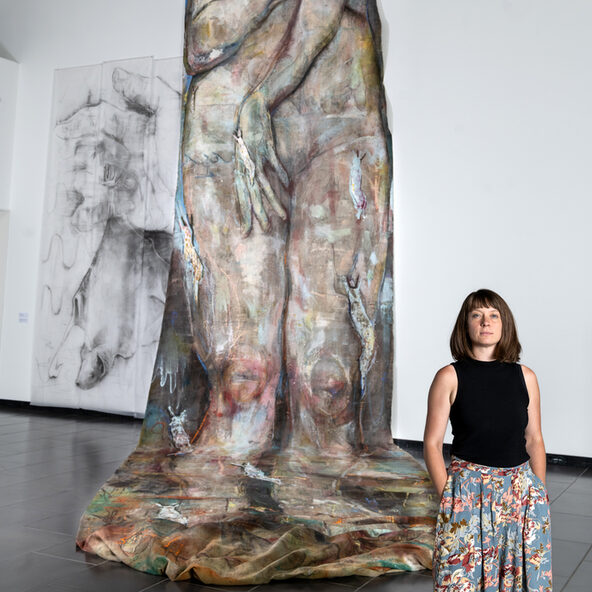 Bild von Lisa Wölfel vor einem Kunstwerk