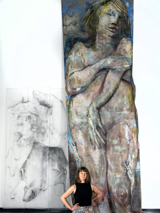 Die Künstlerin Lisa Wölfel steht vor einem ihrer großen Gemälde