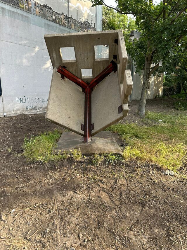 Von der Künstlerin wurde eine 'Haus-Skulptur' geschaffen. Dieses Haus steht auf der Dachspitze unter 45 Grad Neigung. Das Haus wurde aus Fertigteilplatten - über einbetonierte Stahlplatten - aneinandergeschweißt.