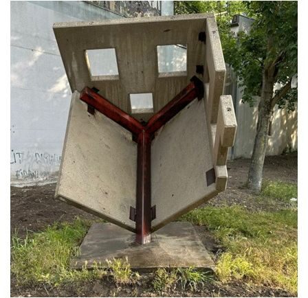 Von der Künstlerin wurde eine 'Haus-Skulptur' geschaffen. Dieses Haus steht auf der Dachspitze unter 45 Grad Neigung. Das Haus wurde aus Fertigteilplatten - über einbetonierte Stahlplatten - aneinandergeschweißt.