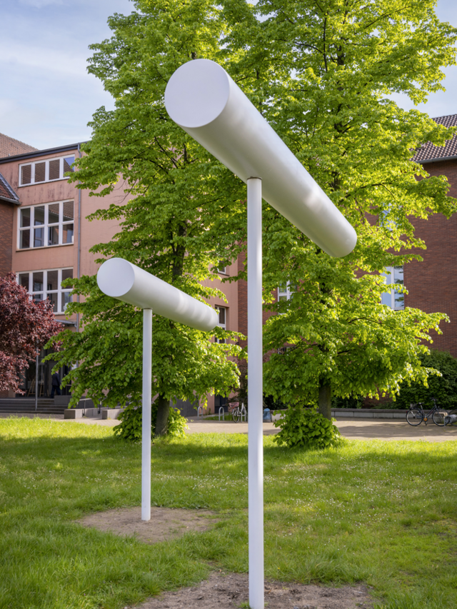 Eine mobile Freiplastik von Erich Reusch, zwei querliegende runde Säulen auf einbetonierten Pfosten. Die Säulen drehen sich im Wind, berühren sich aber nicht.