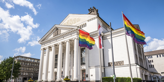 Stadtflagge und Regenbogenflaggen wehen vor dem Stadttheater Duisburg
