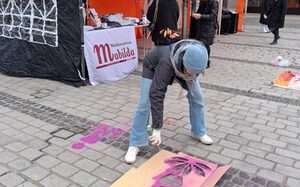 Das Symbol von One Billion Rising wird in pink auf den Boden gesprüht.