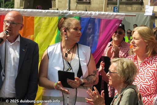 Vier Personen u.a. Oberbürgermeister Sören Link und Bundesministerin Bärbel Bas vor der Regenbogenflagge