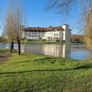 Landhaus Milser Huckingen Hotelanlage mit Teich und Frühjahrsbäumen