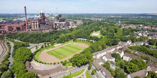 Luftaufnahme - Duisburg-Marxloh -  Schwelgernstadion und Schwelgernpark  mit Hochofenanlage Schwegern im Hintergrund