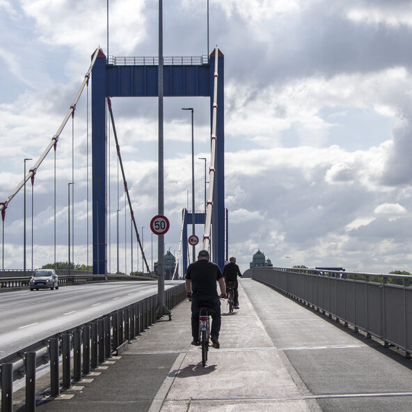 Menschen radeln auf Brücke Richtung Ruhrort