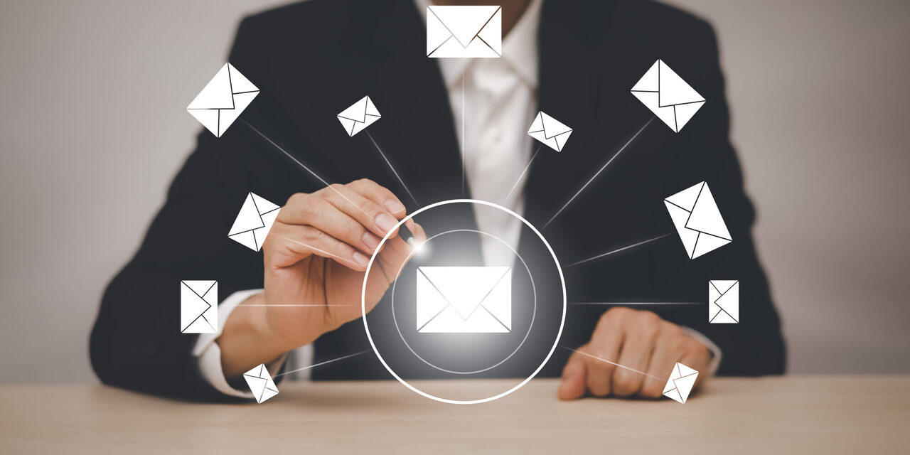 Symbolbild - Mann im Businessanzug, mit einem Touchpen in der Hand und mehrere Briefumschläge in der Luft