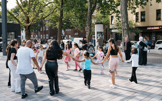 Kinder tanzen zusammen auf einem Platz in Hochfeld