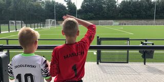 Kinder betrachten den neuen Fußballplatz Paul-Esch-Straße