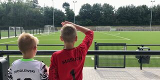 Zwei Kinder schauen auf das neue Fussballfeld