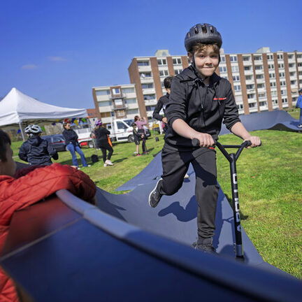 Kind fährt mit Cityroller über einen Pumptrack in Duisburg