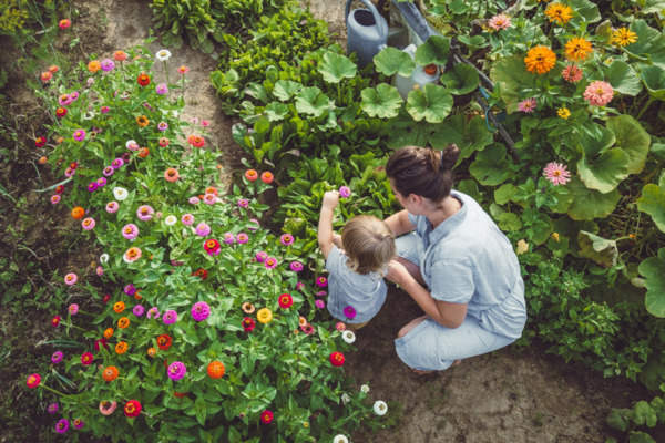 Person mit Kleinkind im Garten