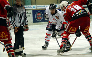 Drei Spieler und der Schiedsrichter auf dem Eis