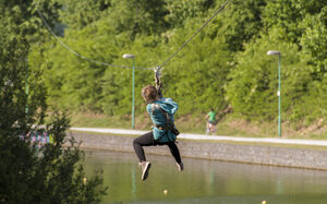 Hochseilkletterer hängt an der Seilbahn.