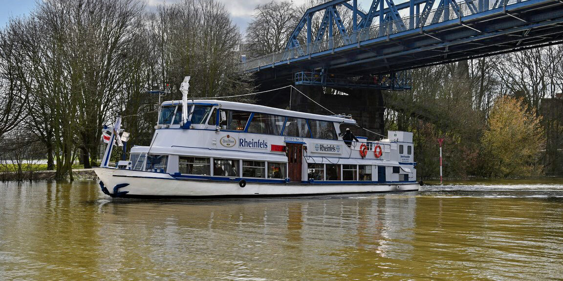 Das Fahrgastschiff Rheinfels fährt unter einer Brücke hindurch.