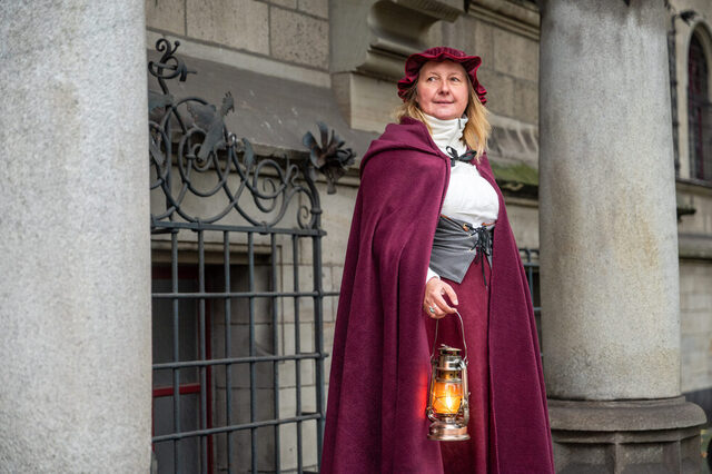 Eine Gästeführerin im Kostüm der vermeintlichen Hexe Agnes Muisfeltz mit einer Laterne in der Hand.
