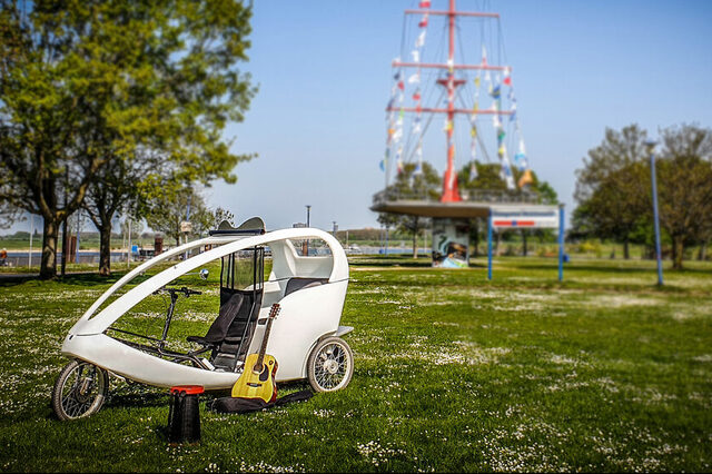 Rikscha "Rieke" steht auf der Mühlenweide, im Hntergrund der Fahnenmast